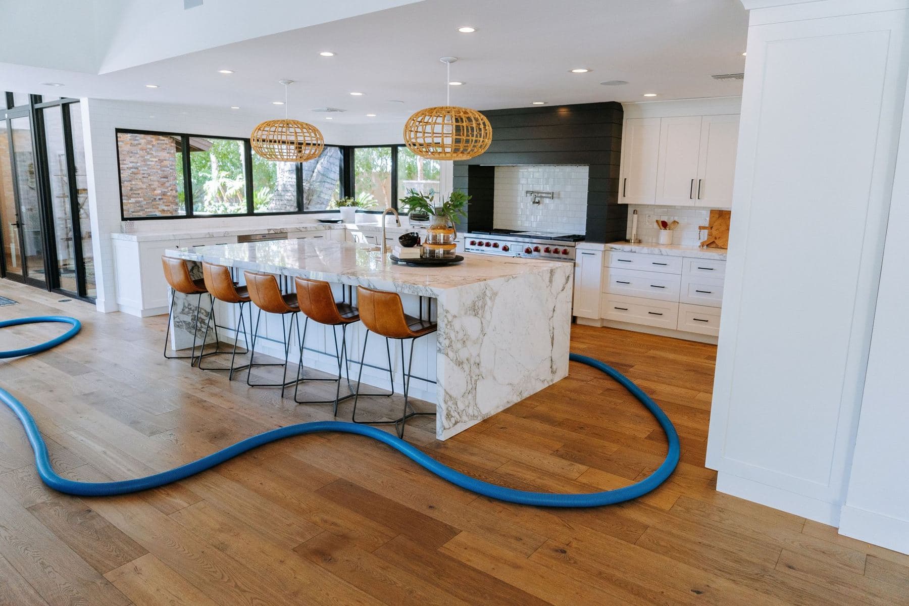 Open kitchen with a Coconut cleaning hose running across the floor